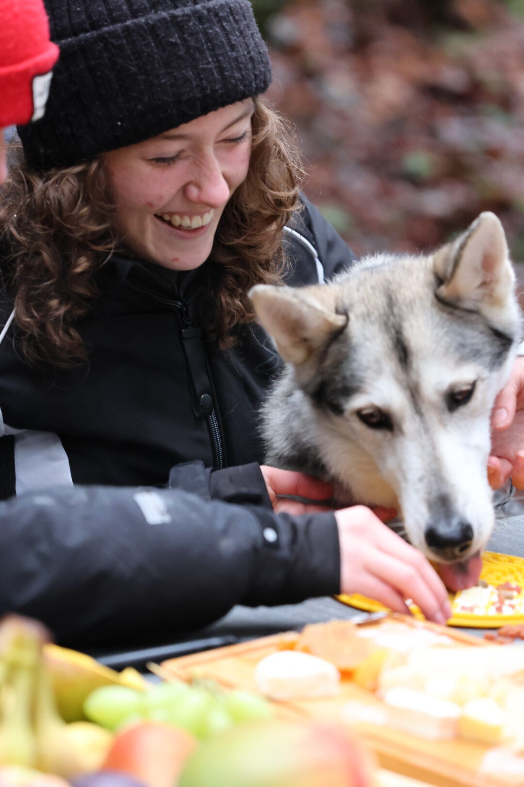 Husky et femme souriante en plein air.